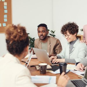 Équipe de professionnels en ressources humaines discutant de la fusion-acquisition et de l'intégration post-fusion autour d'une table.