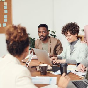 Équipe de professionnels en ressources humaines discutant de la fusion-acquisition et de l'intégration post-fusion autour d'une table.