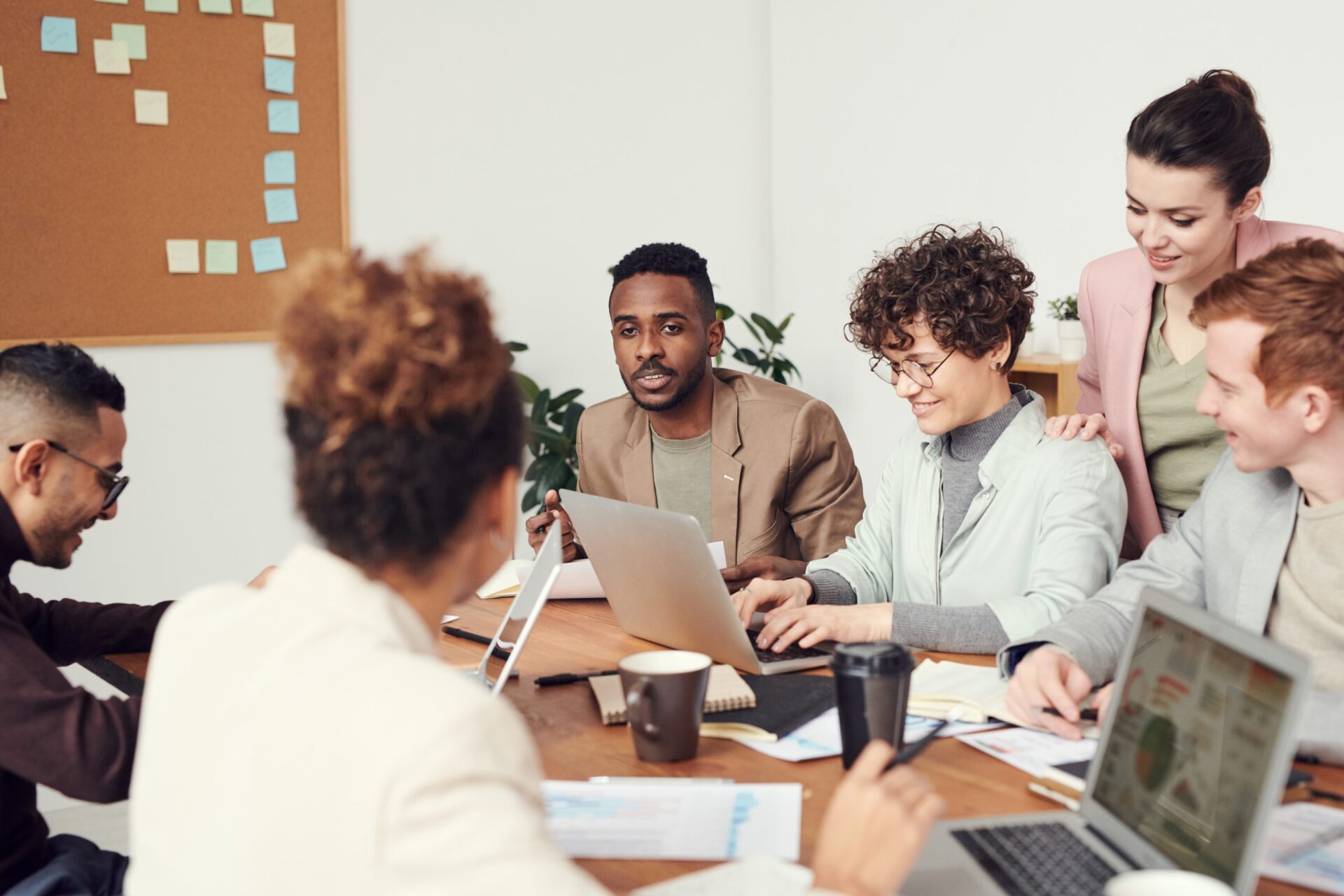 Équipe de professionnels en ressources humaines discutant de la fusion-acquisition et de l'intégration post-fusion autour d'une table.